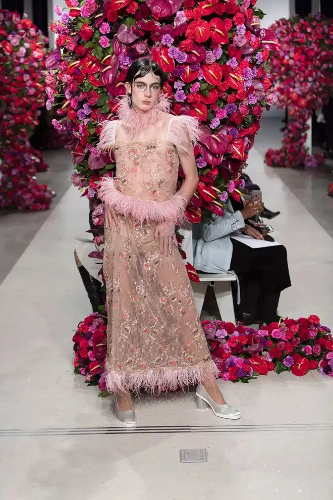 A woman in pink dress standing on the runway.