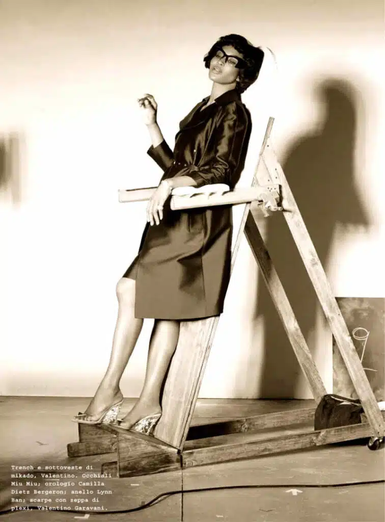 A woman sitting on top of a ladder.