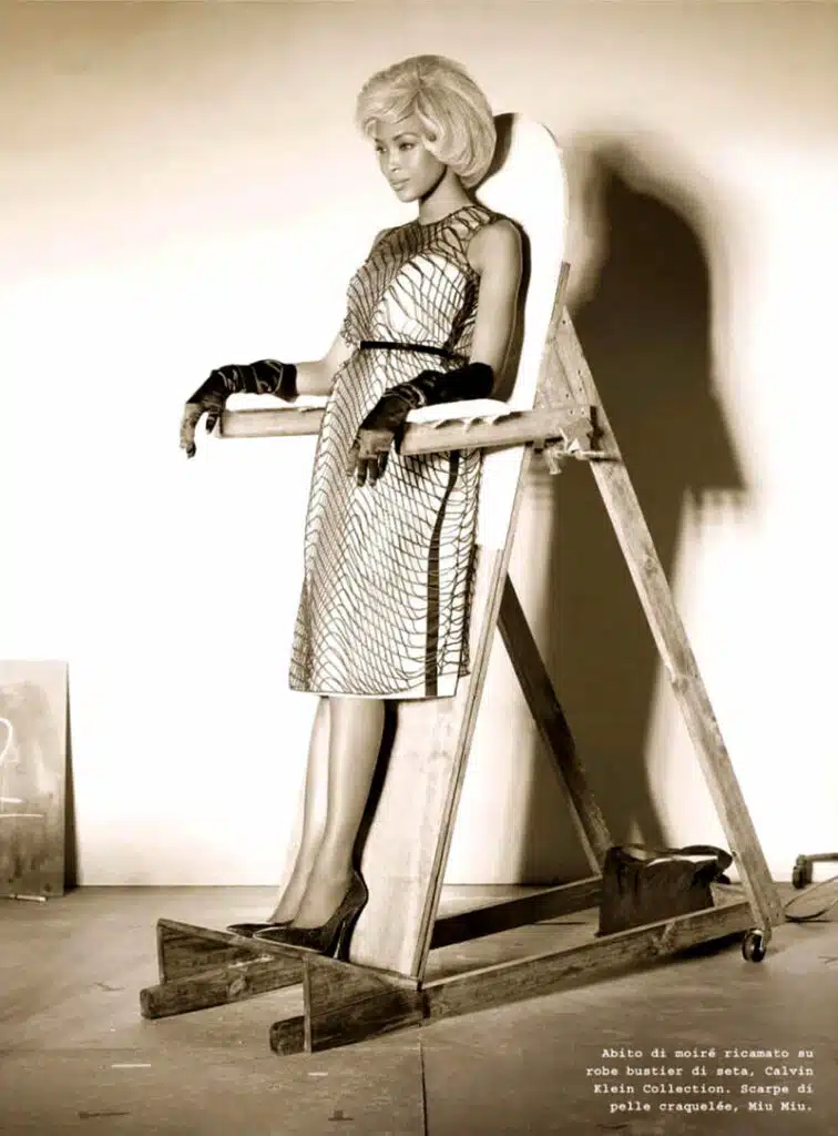 A woman standing on a ladder in front of a wall.