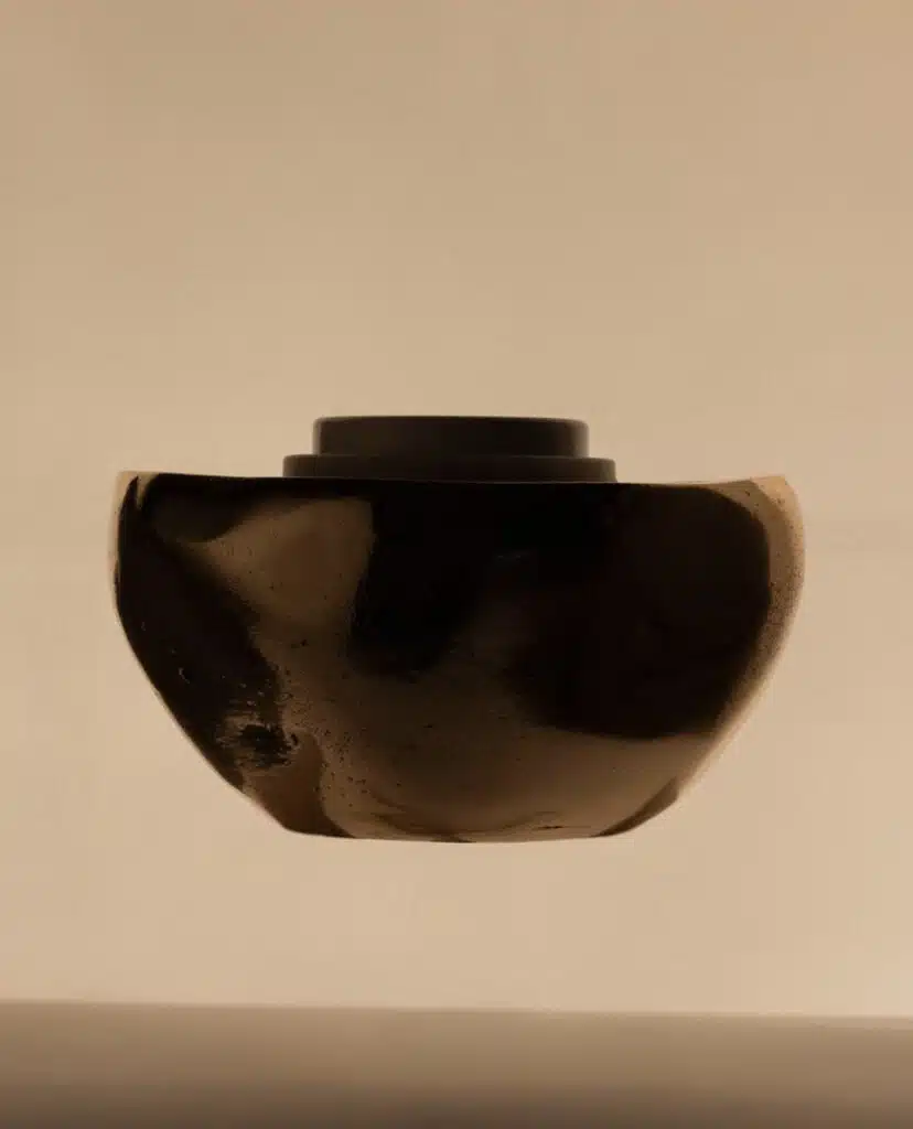 A black vase is shown in the air.