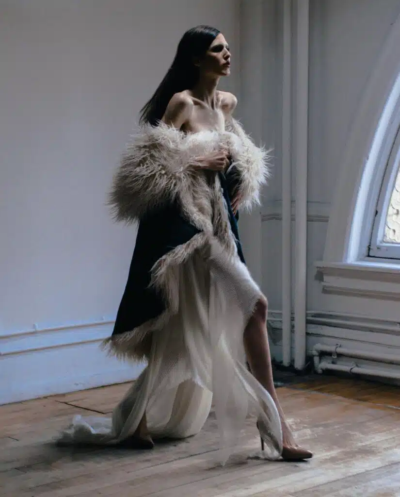 A woman in fur coat walking on the floor.