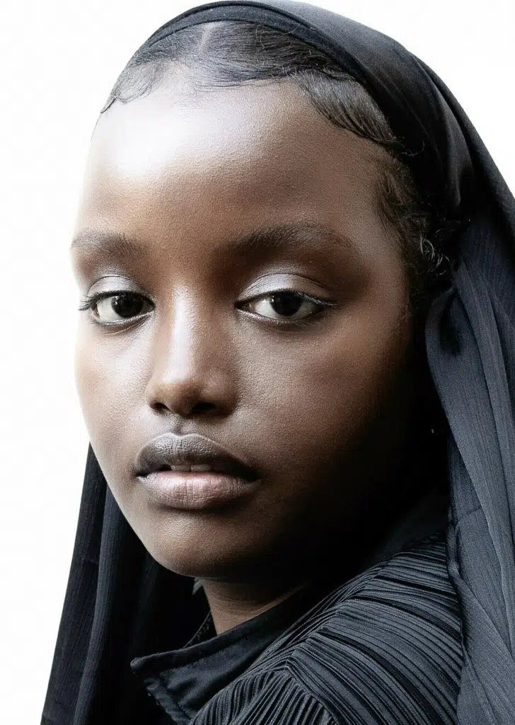 A young woman with a black headscarf and brown eyes.