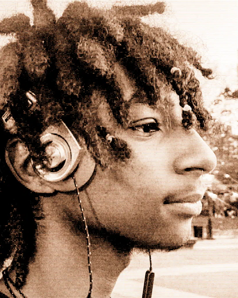 A man with dreadlocks and ear buds in his ears.