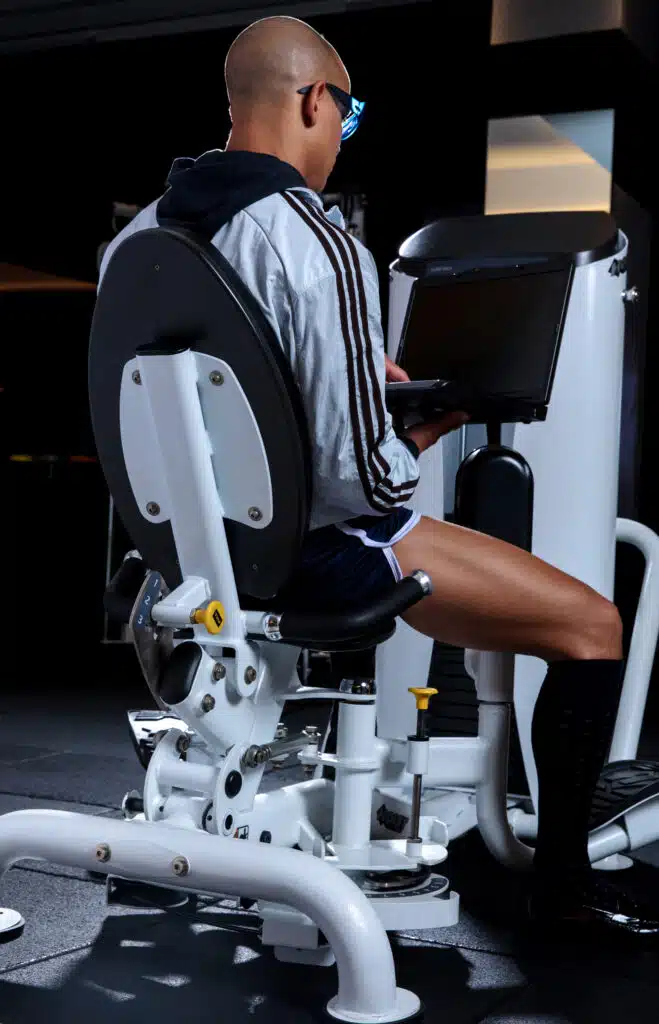 A person using a tablet on the back of an exercise machine.