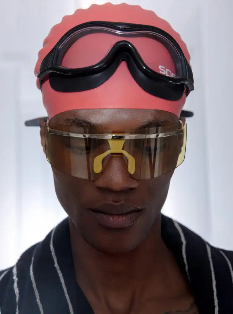 A man wearing goggles and a pink helmet.