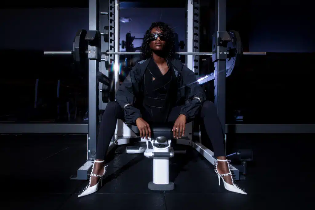 A man sitting on the floor in front of a weight machine.