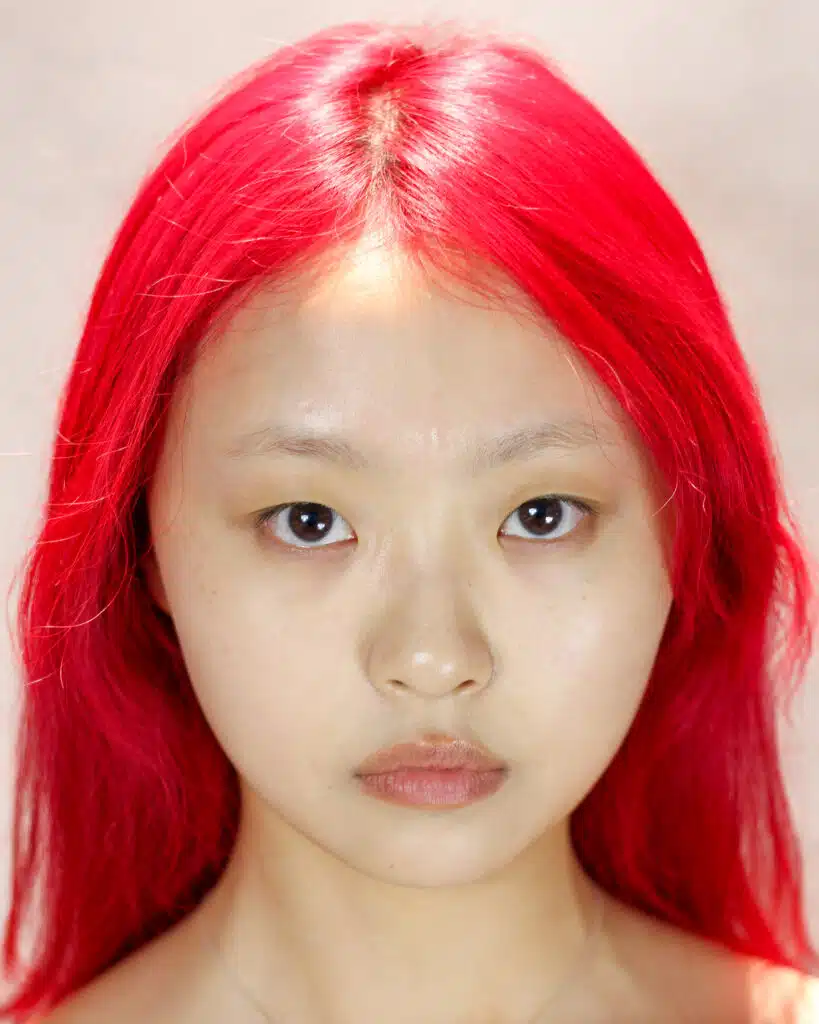 A woman with red hair and no makeup.