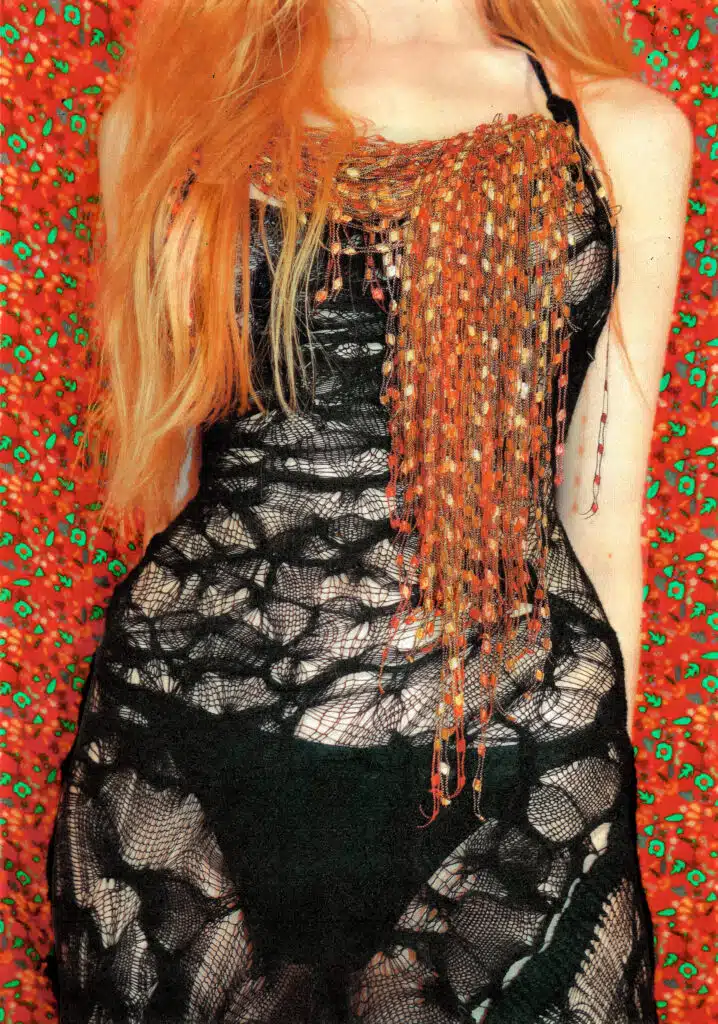 A woman with long red hair and a black dress.