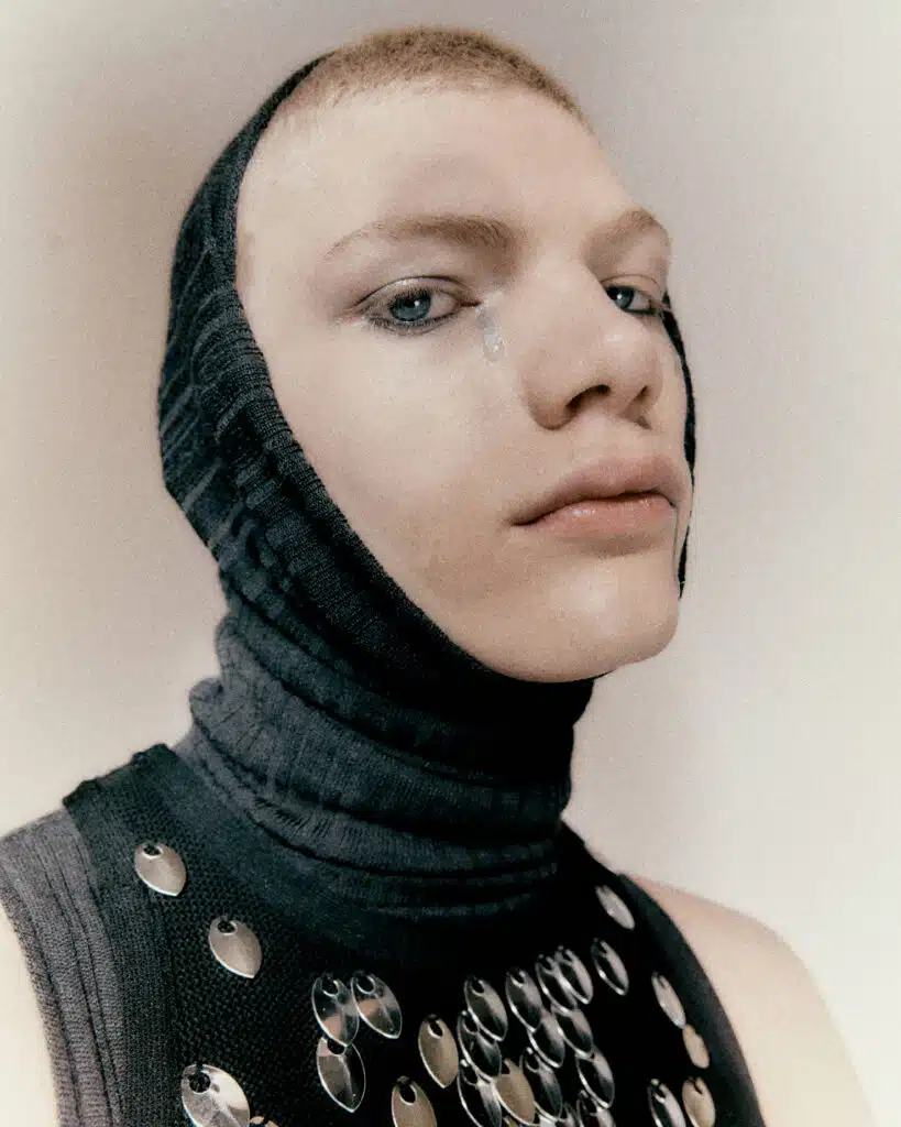 A woman with a black head covering and a necklace.