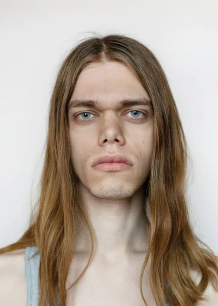 A man with long hair and blue eyes.