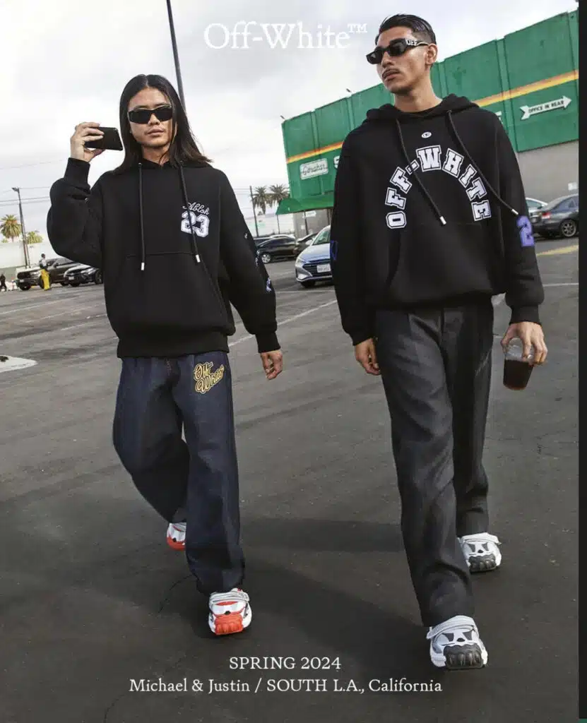 Two men walking down a street wearing black and white clothing.