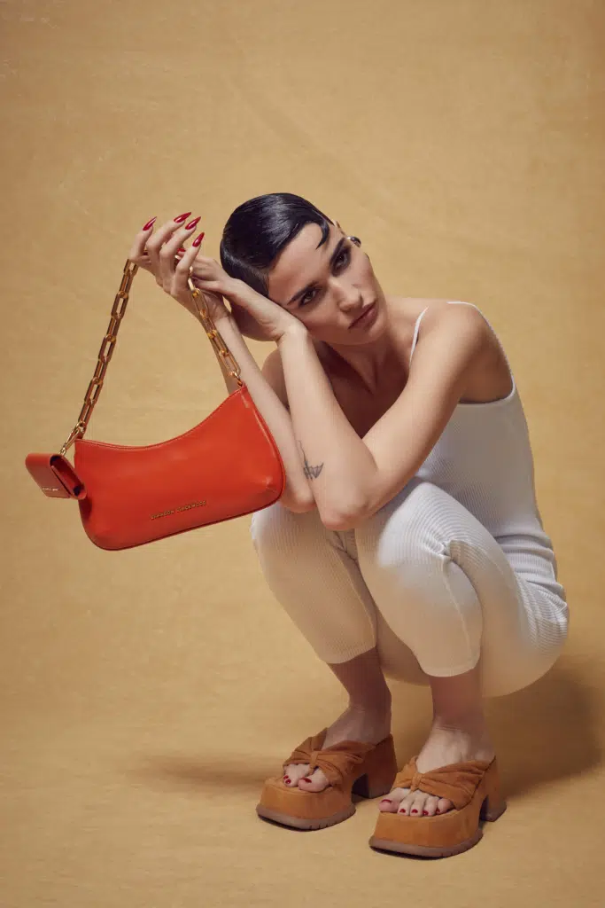 A woman holding onto a red purse