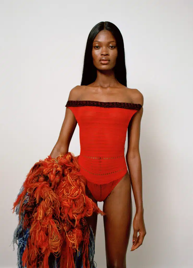 A woman in red is holding a red and brown boa.