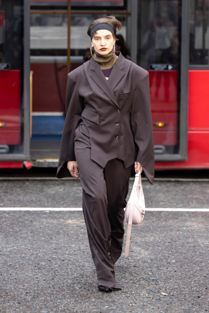 A woman in a suit and scarf walking down the street