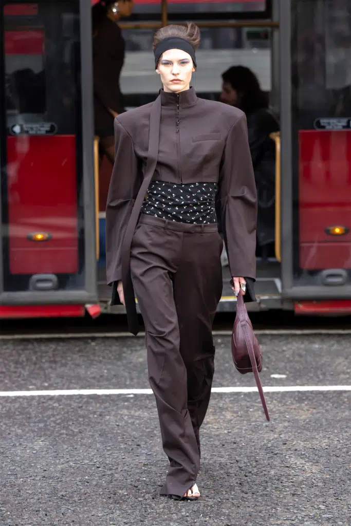 A woman in brown suit walking down the street.