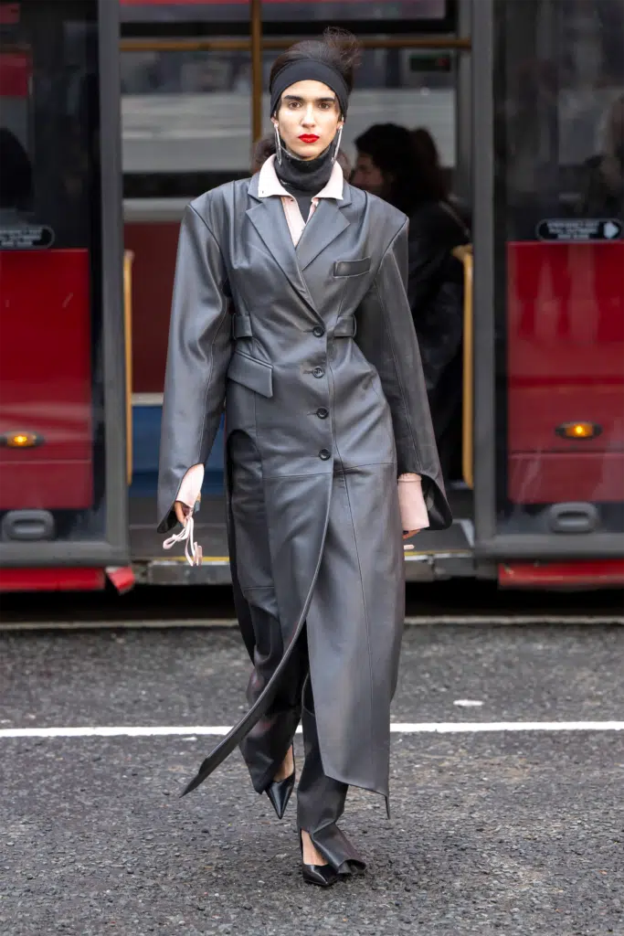 A woman in a suit and tie walking down the street