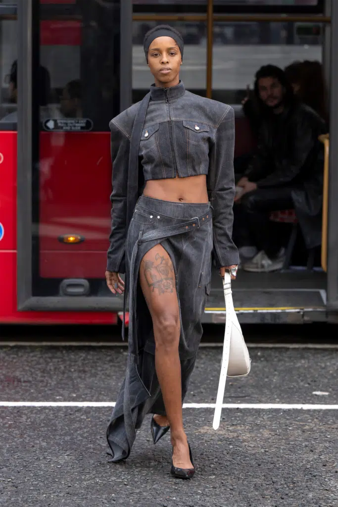 A woman in black outfit holding onto a white bag.