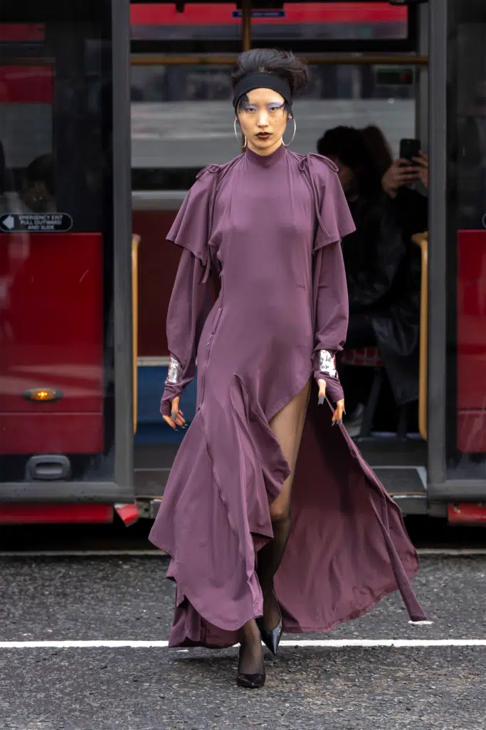 A woman in purple dress walking down the street.