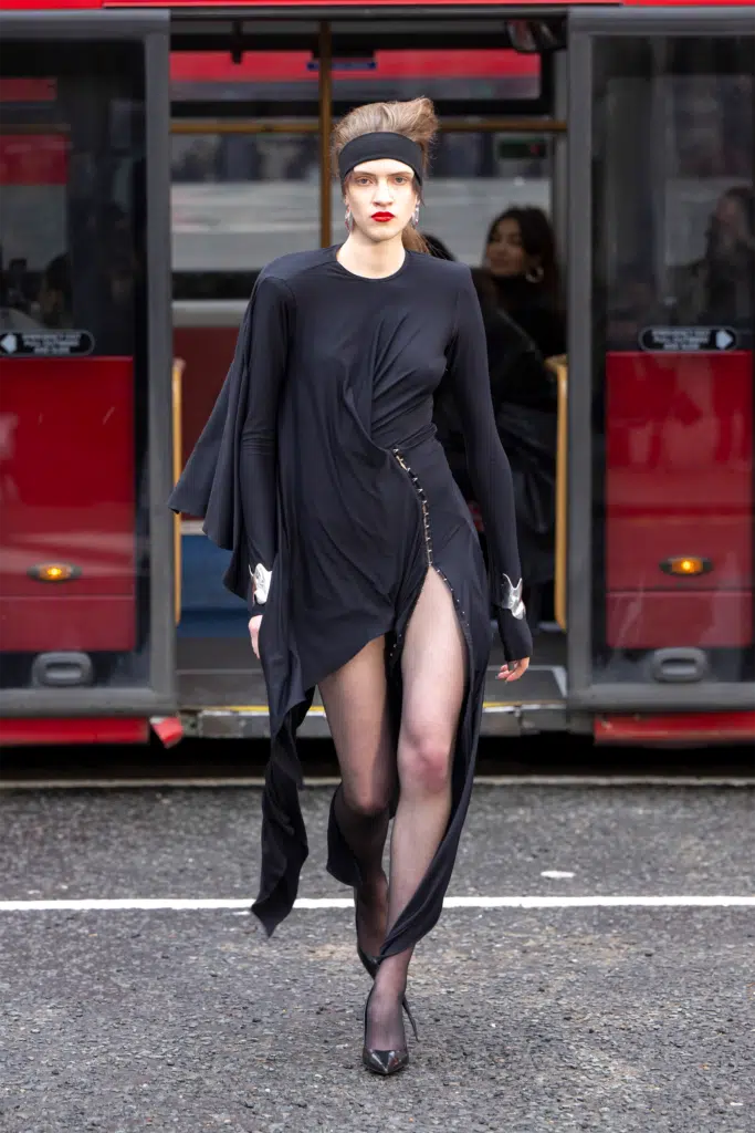 A woman in black dress walking on the street.