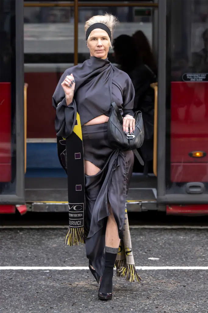 A woman in black dress walking on the street.