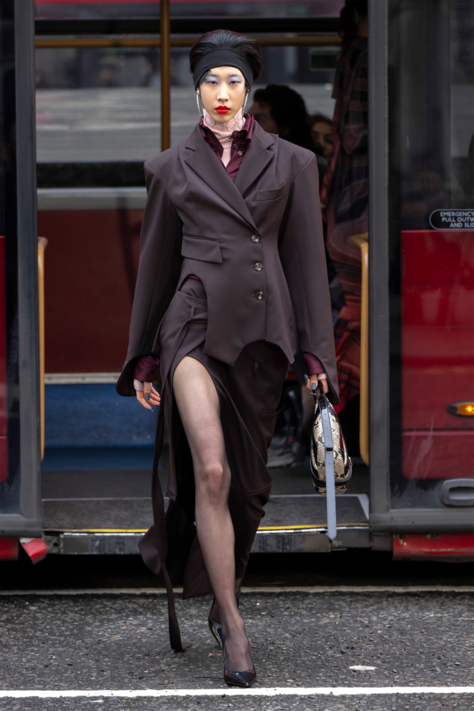 A woman in a suit and stockings walking down the street.