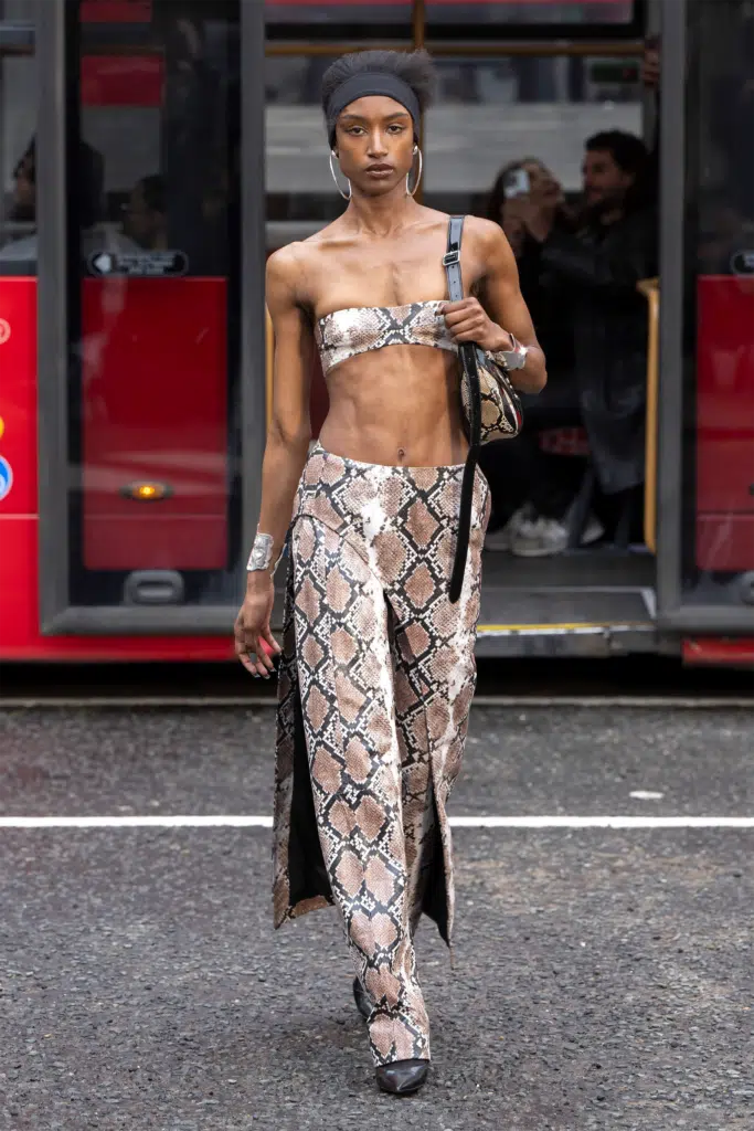 A woman in a snakeskin print outfit walking down the street.