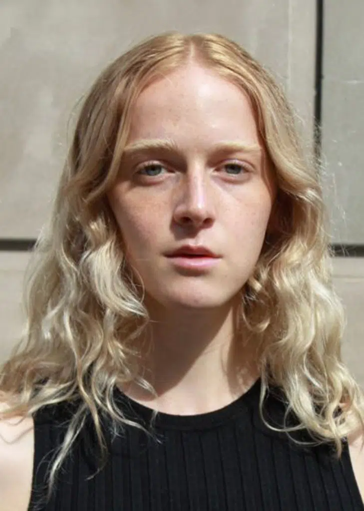 A woman with long blonde hair wearing black shirt.