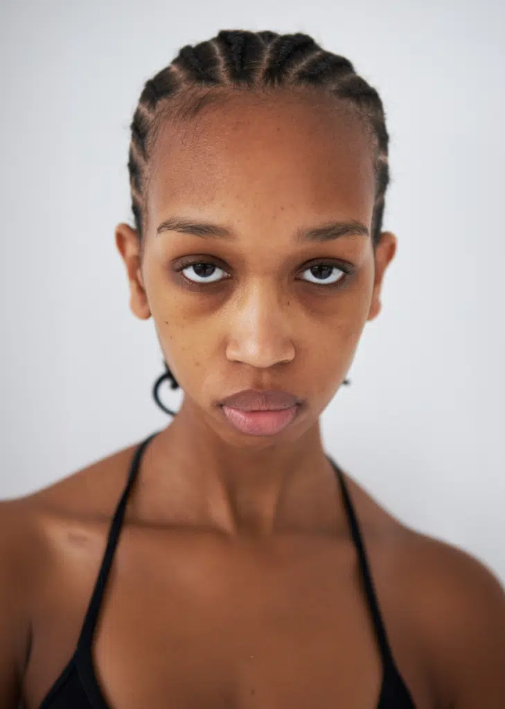 A woman with a black necklace and earrings.