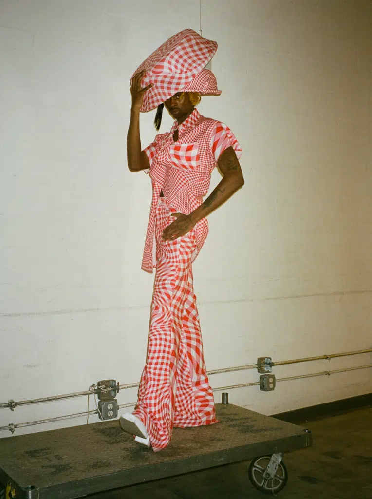 A woman in a red and white outfit standing on the ground.