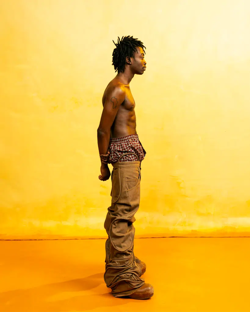 A man standing in front of an orange wall.