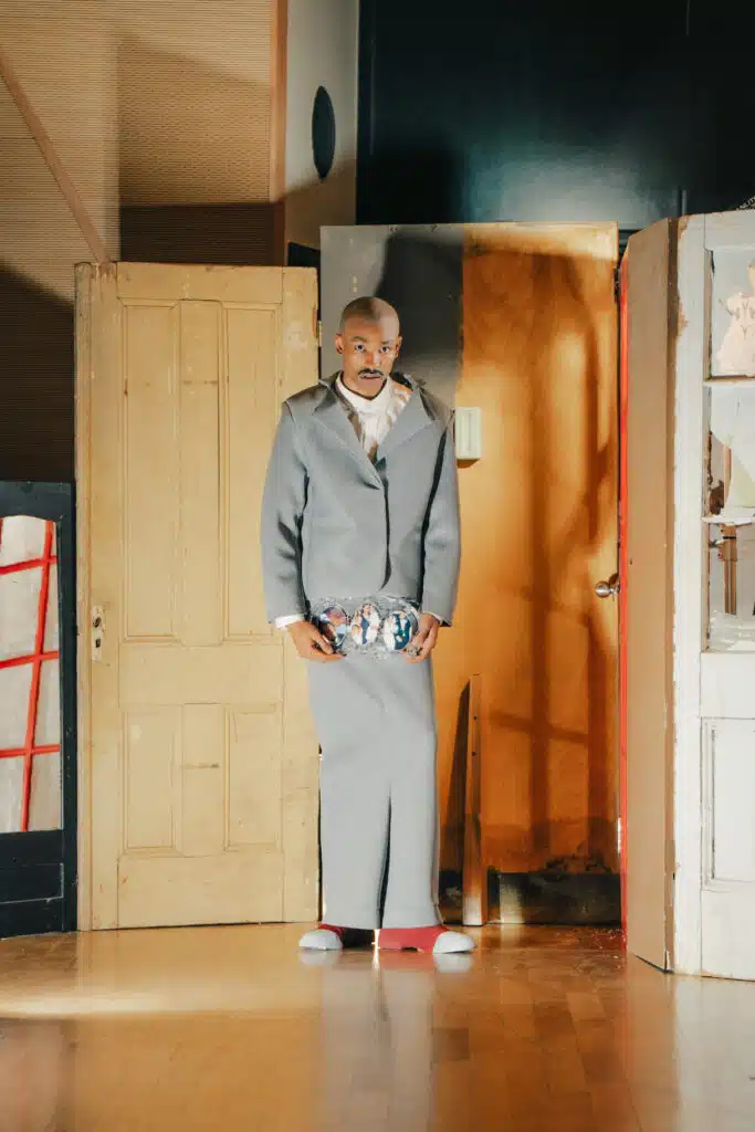 A man in a suit and tie standing next to a door.