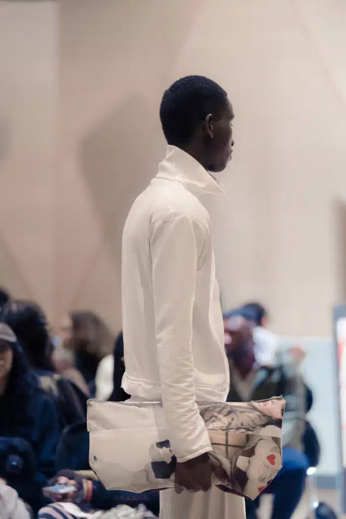 A man in white shirt and black pants standing on a runway.