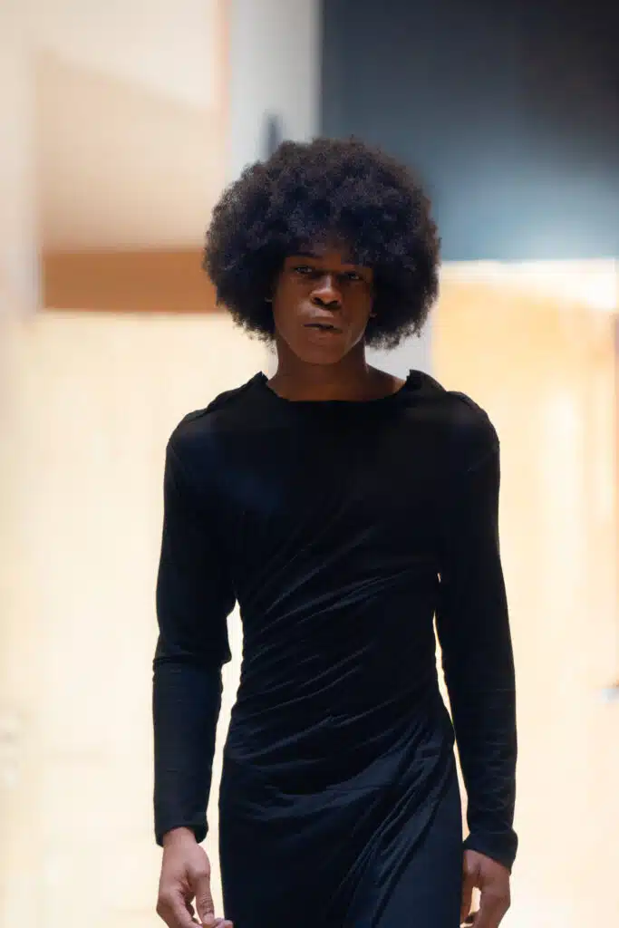 A person with afro hair standing in a room.