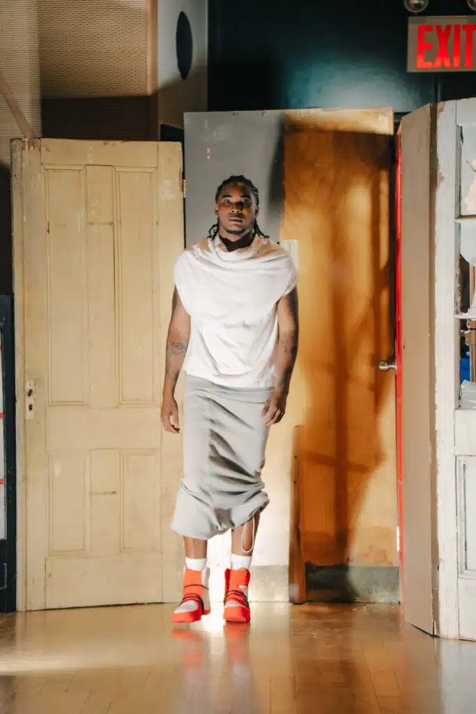 A man standing in front of a door wearing an orange shoe.