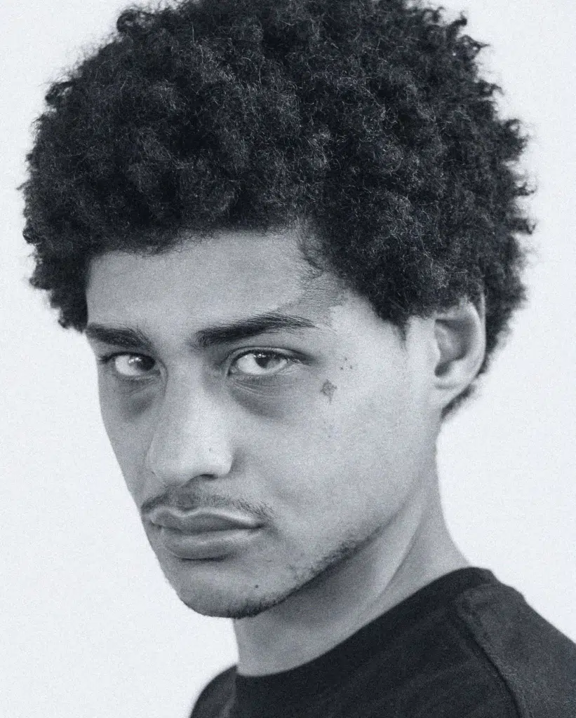 A man with a black shirt and afro