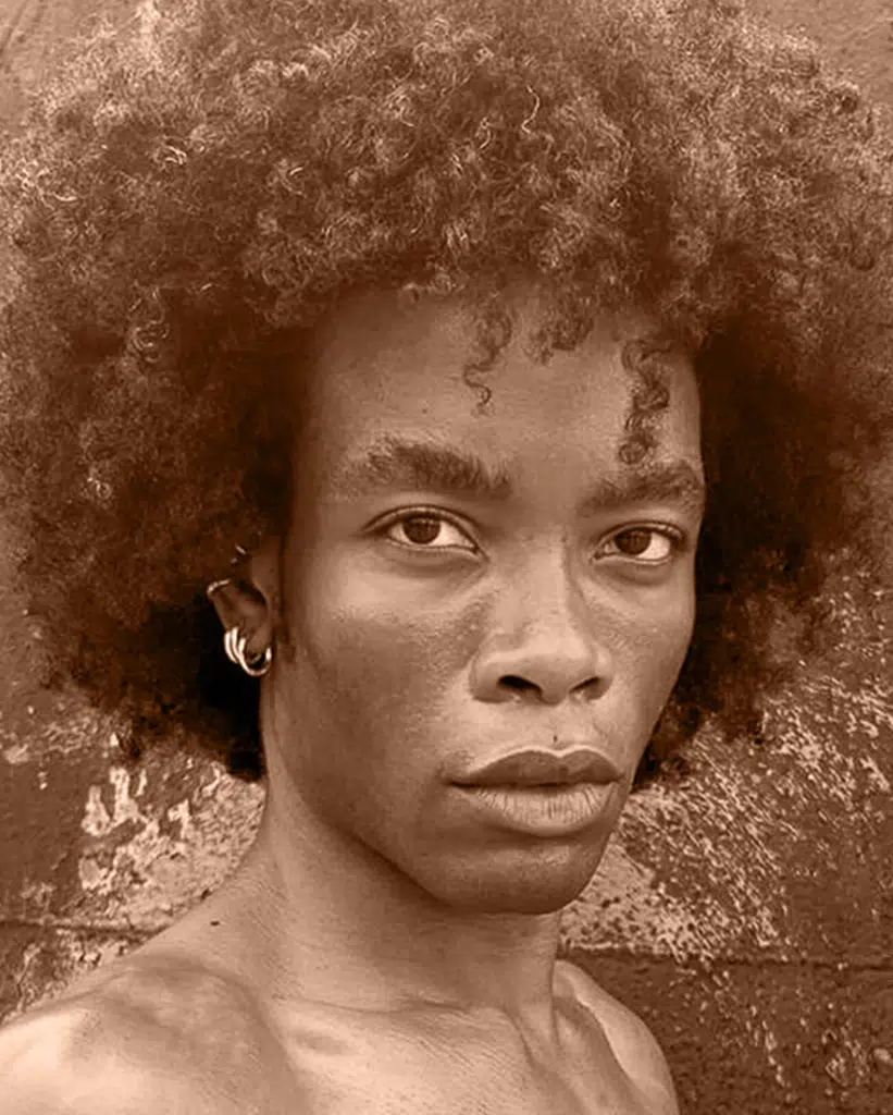 A man with a very large afro is looking at the camera.