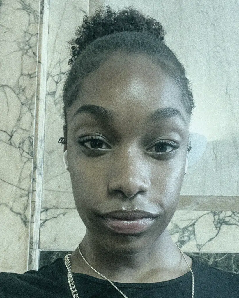 A woman with a black shirt and white marble background