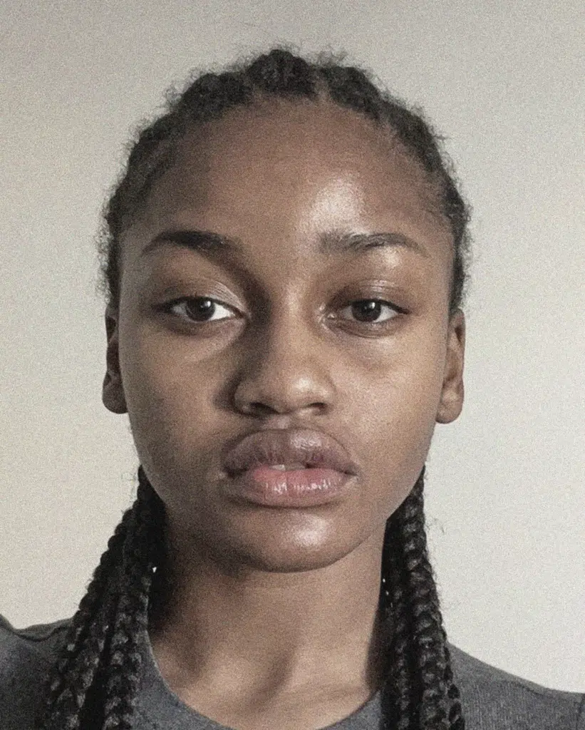 A woman with braids is posing for the camera.