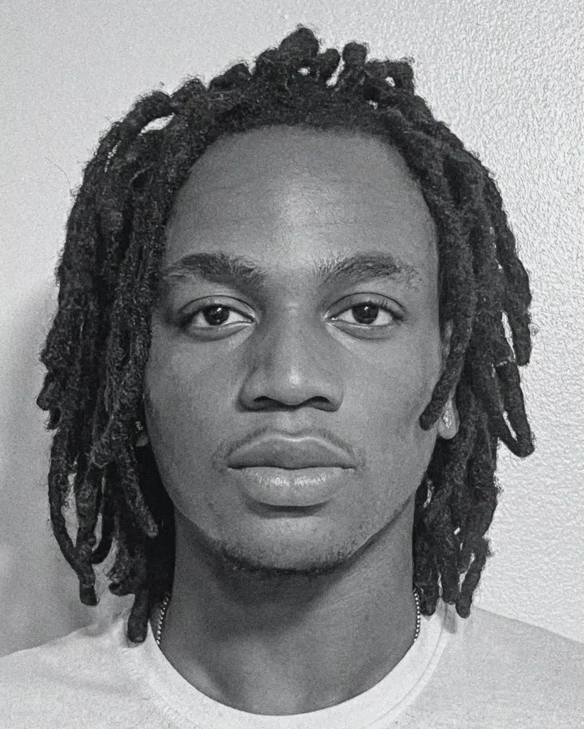 A man with dreadlocks is posing for the camera.