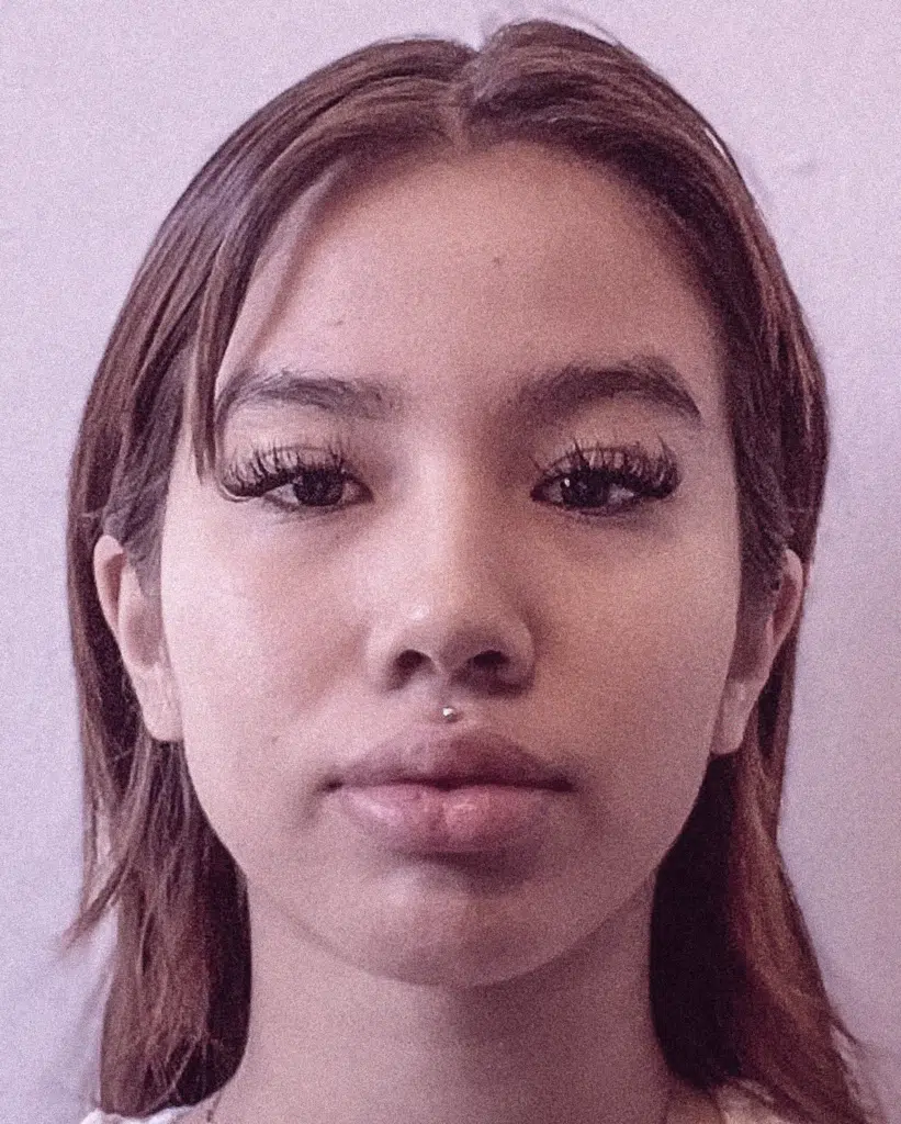 A young woman with long hair and false lashes.