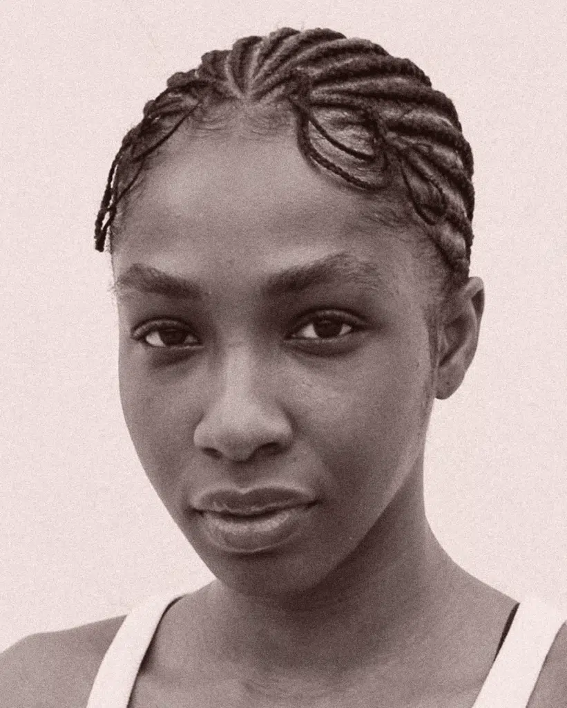 A black and white photo of a woman with braids.