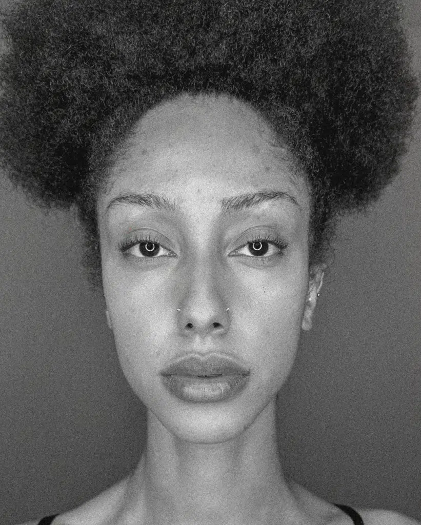 A black and white photo of a woman with an afro.