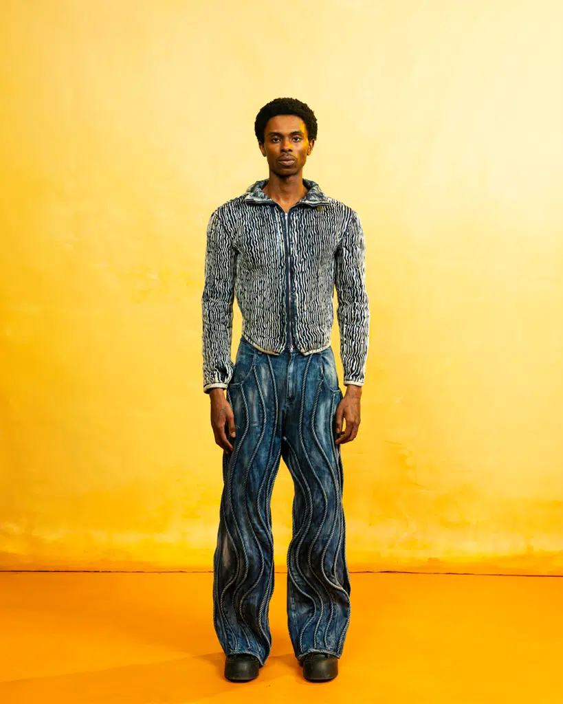 A man standing in front of an orange wall.