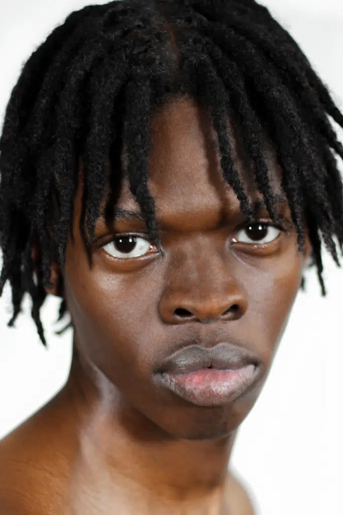 A young man with dreadlocks and black skin.