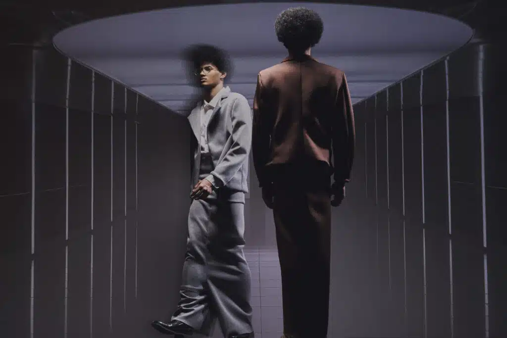 Two men in suits are walking through a tunnel.