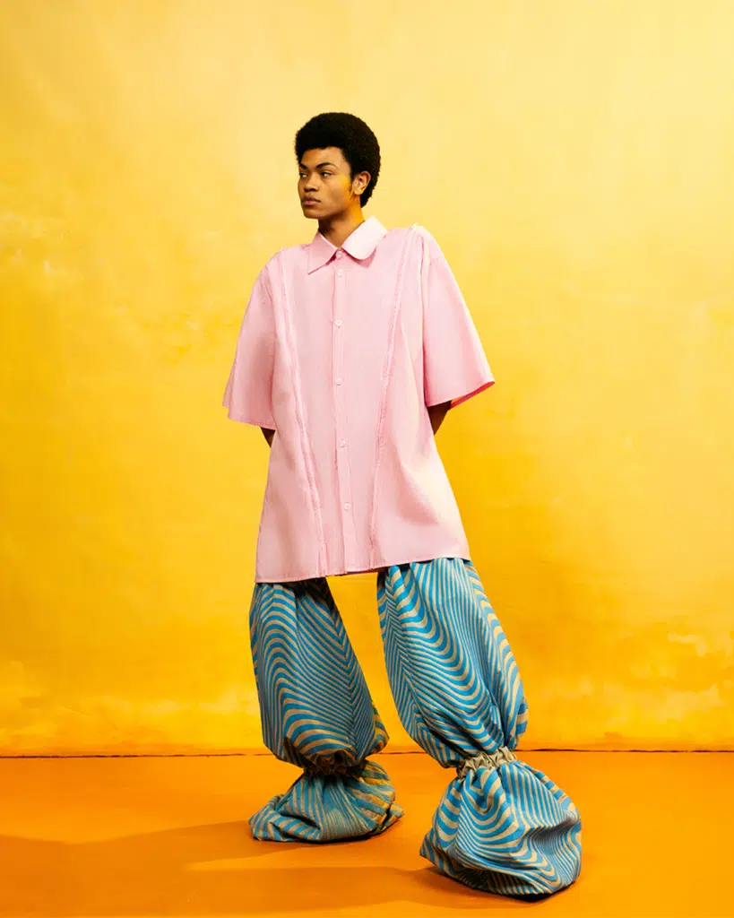 A person standing in front of a yellow wall.