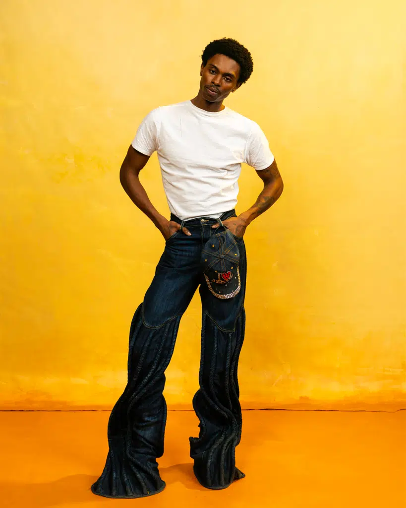 A man in white shirt and jeans posing for the camera.