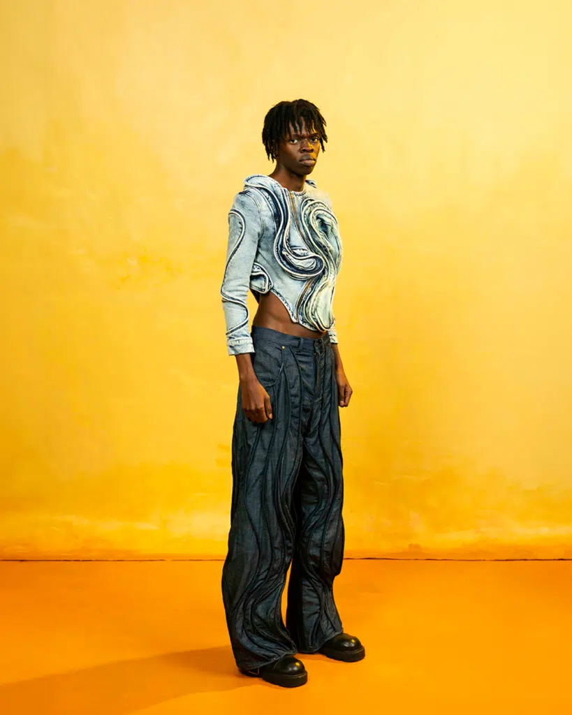 A person standing in front of an orange wall.