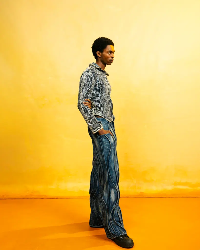 A man standing in front of an orange wall.